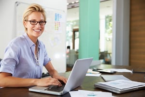 an accounting professional uses workflow management software on her laptop